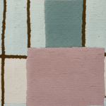 A close-up of a textured, high-pile area rug with a geometric block pattern in dusty pink, sage green, cream, and light blue, separated by dark brown lines.