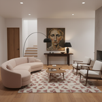 A modern living room featuring a curved blush pink sofa, two mid-century modern armchairs, a patterned rug, and a large portrait painting on the wall.