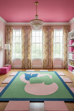 Pink room with a large rug featuring a extended sides, pink walls, and a chandelier.