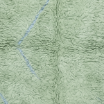 A close-up of a light sage green plush fleece blanket with a textured, looped surface and a subtle stitched geometric pattern.