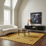 A yellow area rug with black and coral polka dots is styled in a modern living room with a white curved sofa, black coffee table, and a large abstract painting on the wall.