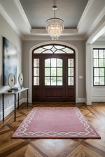 Foyer with a pink rug, wooden door, and chandelier.
