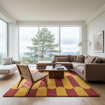 A modern living room with a large sectional sofa, a matching armchair, a low wooden coffee table, and a bold patterned area rug in yellow, red, and brown tones. Large windows offer a view of a pine tree and ocean, and the room is styled with neutral decor.
