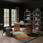 Modern home office with wooden desk, bookshelves, decorative rug, and large windows.