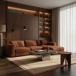 A modern living room featuring a warm rust-brown sectional sofa, a dark wood coffee table, a patterned beige rug, and a large built-in wooden bookshelf with warm ambient lighting in the background.