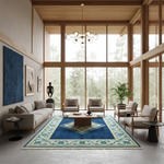 A modern living room with a large blue and cream patterned area rug on the floor, surrounded by a gray sofa, two wooden armchairs, a coffee table, and tall windows overlooking a forest.