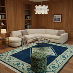 A modern living room with a cream curved sectional sofa, a large blue and beige patterned area rug, a green patterned cylindrical ottoman, and wood-paneled walls with built-in bookshelves.