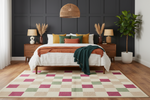 Bedroom with a checkered rug, bed with colorful bedding, and dark paneled walls.