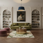 A styled living room interior featuring a green sofa, a round gold coffee table, a patterned rug, built-in white bookshelves, and a large framed portrait on the wall.