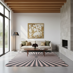 A modern living room featuring a large rectangular area rug with a pink and dark gray sunburst pattern, styled with a beige sofa, a wooden coffee table, and a gold abstract painting on the wall.