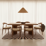 Dining room with wooden table and chairs on a striped scalloped rug
