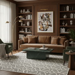 A styled living room interior featuring a brown leather sofa centered against dark wood built-in shelves, with a green marble coffee table, patterned rug, green armchairs, and abstract wall art.