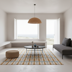 A modern living room interior with a patterned area rug, a round black coffee table, a woven pendant light, a gray sofa, and large windows overlooking a bright outdoor view.