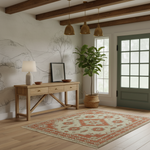 A styled interior room scene showing a light wood console table with a lamp and framed art, a potted plant, a patterned area rug, exposed wood ceiling beams, and a green door. No person or animal is present, but this is not a clean isolated product shot; it is a real environment, so subject_type is Lifestyle.