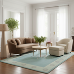 A styled living room featuring a large light blue area rug with a beige border, styled with a brown sofa, cream armchair, and coffee table.