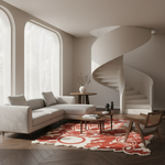 A modern living room with a light beige sectional sofa, a red and cream patterned area rug, a wooden chair, and a white spiral staircase in the background.