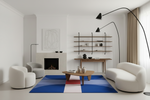Modern living room with white sofa, armchair, and colorful blue contemporary rug.