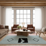 A styled living room interior with a light blue shag area rug featuring black geometric diamond and chevron motifs, surrounded by a light wood coffee table, two brown armchairs, a sofa, and large windows with white curtains.
