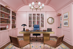 Pink office with a desk, chairs, pink rug, and bookshelves.