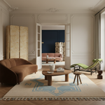 Modern living room with brown sofa, round coffee table, shaggy rug, and green lounge chair.