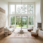 Modern living room with large windows, white furniture, and a decorative rug.