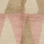 Close-up of a plush sherpa fabric with a geometric pattern in dusty pink, beige, and cream.
