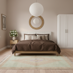 A styled bedroom scene featuring a wooden bed frame with a white upholstered headboard, dressed in brown bedding and neutral pillows. The bed is placed on a light green and beige patterned rug, with a small wooden side table holding a white vase of flowers to the left, and a white wardrobe against the right wall.