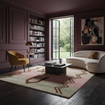 A styled living room interior with a curved cream sofa, mustard yellow armchair, black coffee table, patterned area rug, bookshelves, and a large abstract painting on a mauve wall. No people or animals are present.