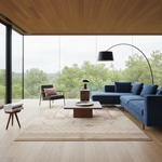 A modern living room with a large blue sectional sofa, a black armchair with a pink pillow, a low wooden coffee table, a beige patterned rug, and a black floor lamp, set against a backdrop of large windows showing a forest view.