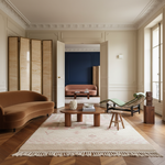 Modern living room with a brown sofa, wooden coffee table, and decorative rug.