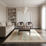 A beautifully styled living room featuring a light beige sofa, a dark wood coffee table, a large beige and mint green patterned area rug, two wooden armchairs, built-in shelves, and a modern tiered chandelier.