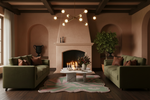 Cozy living room with green rug, sofas, a fireplace, and decorative items.