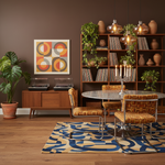Living room with a bookshelf, rug, table, chairs, and decorative elements.