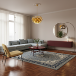 A modern living room scene with a light blue sectional sofa, a yellow accent chair, a patterned blue and beige area rug, a red round coffee table, and a gold pendant light hanging from a white ceiling.