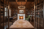 Cozy library with wooden bookshelves, peach traditional rug, fireplace, and armchair.