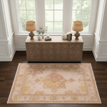 A rectangular area rug with a traditional medallion pattern in beige, pink, and yellow, styled on a dark wood floor in front of a wooden console table with two lamps.