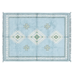A rectangular light blue rug with white and sage green geometric diamond patterns and fringed edges, shown flat against a white background.