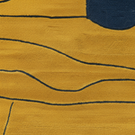 A close-up of a textured mustard yellow rug with abstract navy blue lines and a partial navy blue circular shape.
