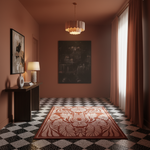 A large rectangular area rug with a bold floral and leaf pattern in terracotta and cream, displayed on a black and white checkered floor in a styled room with warm terracotta walls, a chandelier, and a console table.