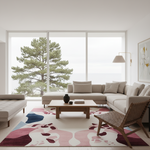 A modern living room with a large beige sectional sofa, matching armchair, wooden coffee table, and a colorful abstract area rug. Large floor-to-ceiling windows show a pine tree and overcast sky, with a wall lamp and framed art on the right.