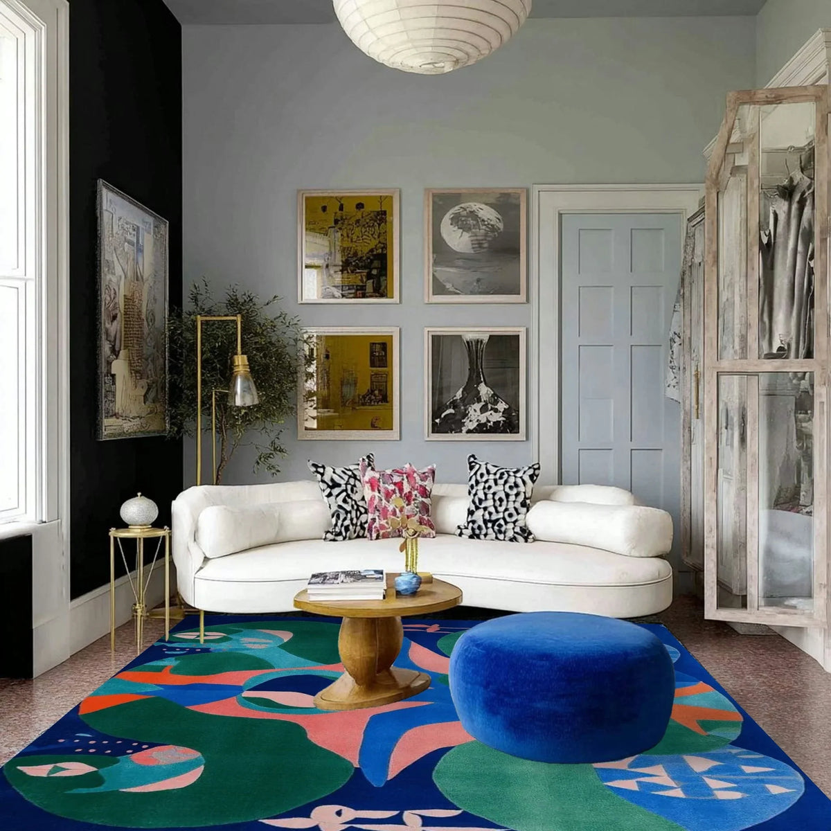 Modern living room with a white sofa, colorful rug, and decorative pillows.