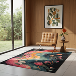 A rectangular area rug with a colorful floral and abstract design in pink, teal, orange, and black, styled in a modern room with a tan leather chair, wood-paneled walls, and a large window.