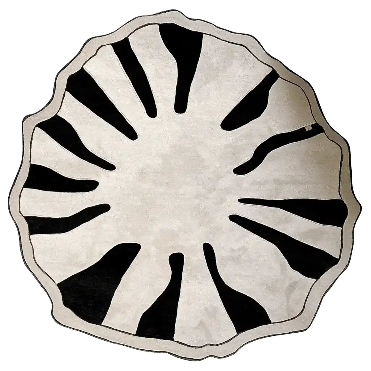 Form and Edge hand tufted rug swatch, a round cream mat with a scalloped grey edge and black flame shapes radiating in