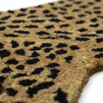 Close-up of a plush textured fabric with a leopard print pattern, featuring a tan base with black spots, on a white background.