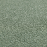 A close-up texture shot of a soft, dense loop-pile carpet in a muted sage green color.