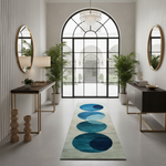 A long runner rug with a modern abstract design of overlapping blue and teal circles on a light beige background, styled in a bright, contemporary entryway with a large arched window, side tables, and potted plants.