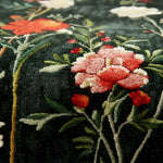 Close-up of floral rug with pink and red flowers on a dark background