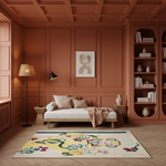 A styled interior room with terracotta paneled walls, a cream daybed with pillows and a throw, a floor lamp, shelving, and a colorful abstract area rug on a wood floor.