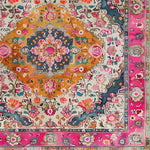Colorful floral and geometric patterned rug with a pink border