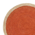 A close-up of a round woven rug with a warm rust-orange center and a natural beige braided border on a white background.
